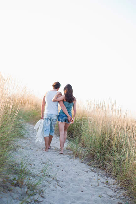 Paar spaziert am Strand entlang — Stockfoto