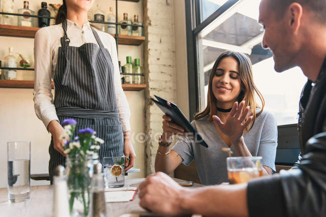Young woman paying bill at cocktail bar table — Stock Photo