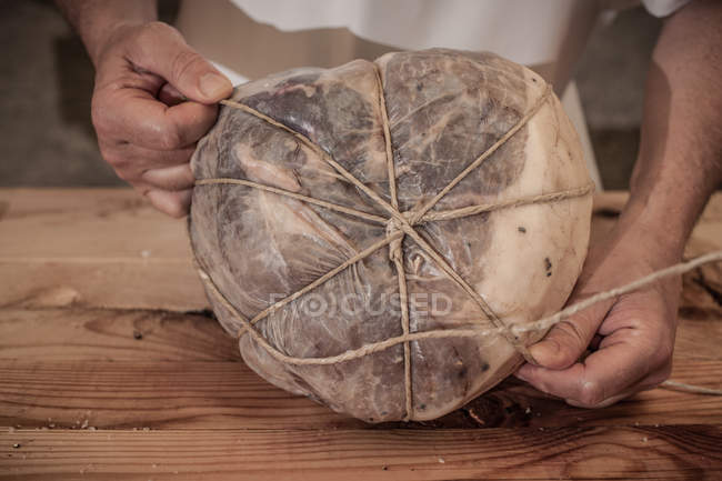 Butcher tying meat in shop, close-up partial view — Stock Photo