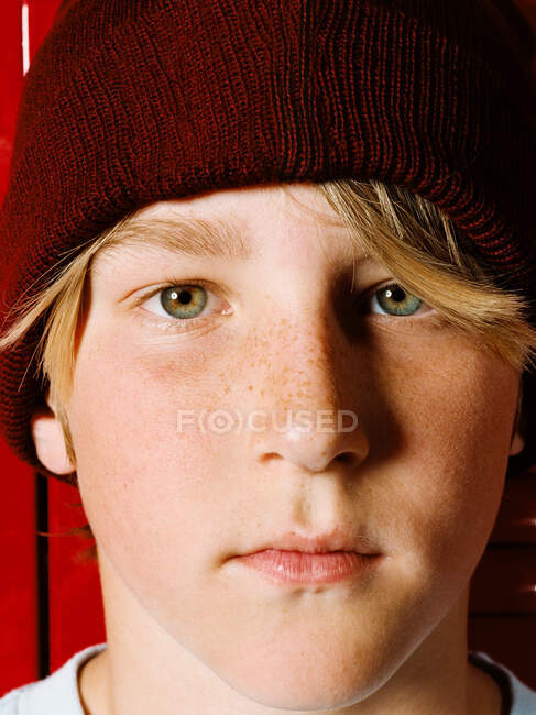 Boy wearing knit hat in school locker room, portrait — Stock Photo