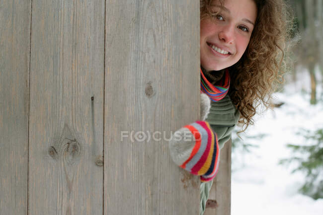 Mujer escondida detrás de una valla - foto de stock