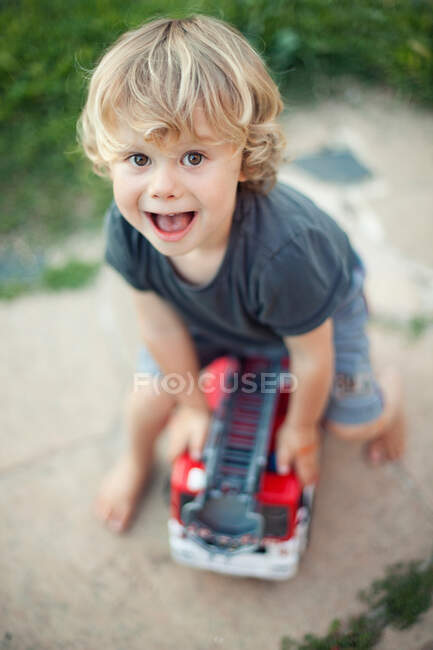 Menino brincando com motor de fogo de brinquedo — Fotografia de Stock