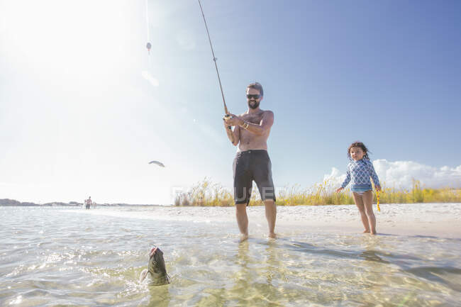 Fille regardant père attraper des poissons en mer, Fort Walton Beach, Floride, États-Unis — Photo de stock