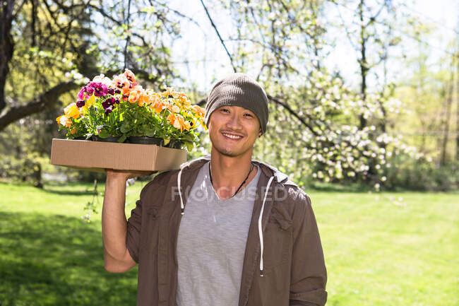 Man holding box of flowers — Stock Photo