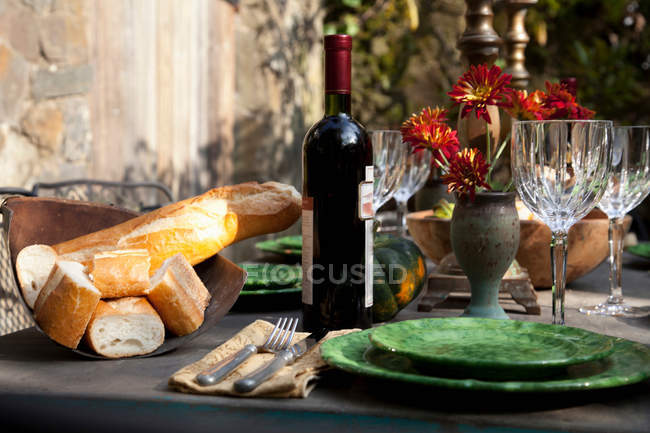 Botella de pan y vino en la mesa - foto de stock