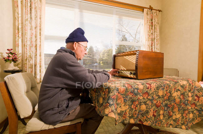 Старший чоловік настроює радіо — стокове фото