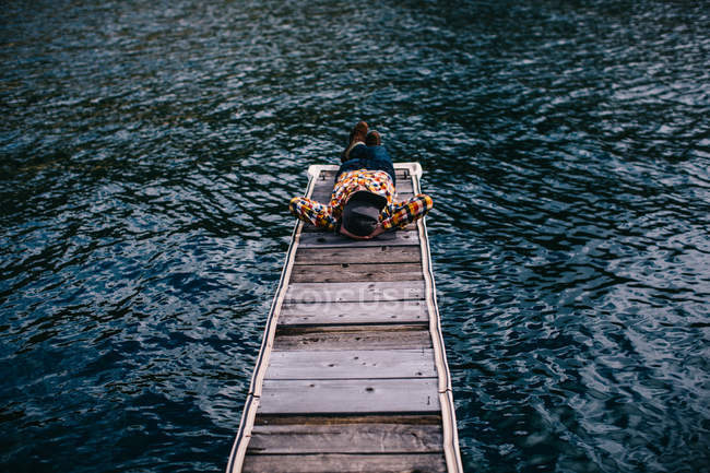 Junger Mann legt sich auf Pier am Rasiersee, Kalifornien, USA — Stockfoto