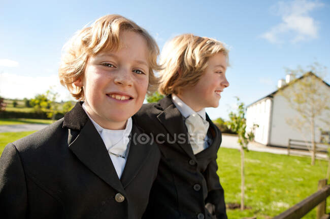 Boys wearing horse riding clothes, smiling — Stock Photo