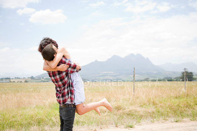 Paar umarmt sich auf Feld — Stockfoto