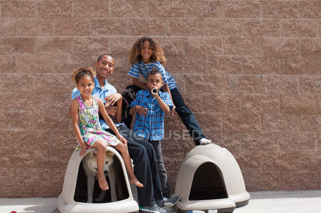 Portrait of four siblings and dog in kennel — Stock Photo