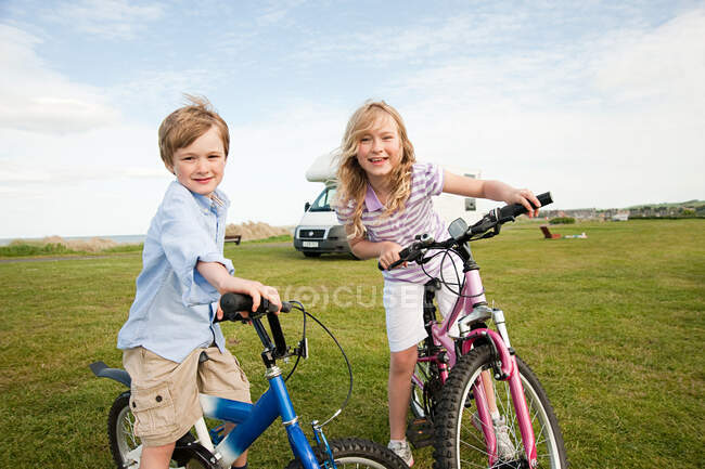 Брат и сестра с велосипедами — стоковое фото