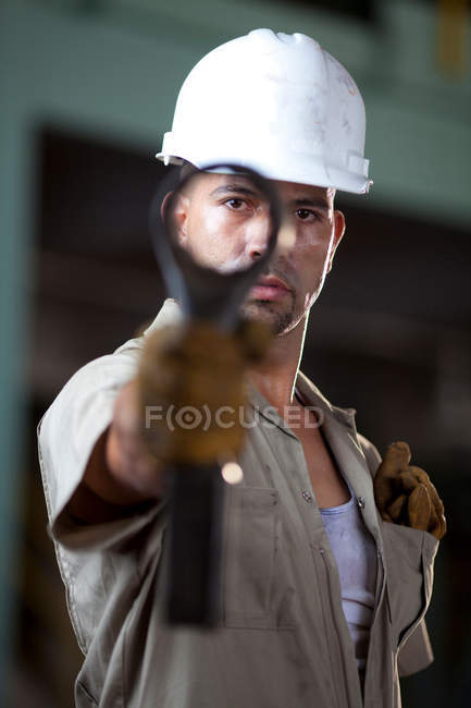 Промисловий працівник тримає інструмент на заводі — стокове фото