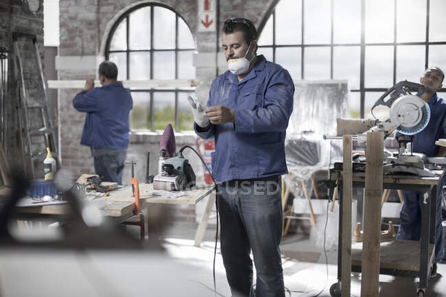 Cape Town, South Africa, machinist safetly applying his gloves before using workshop equipmet — Stock Photo