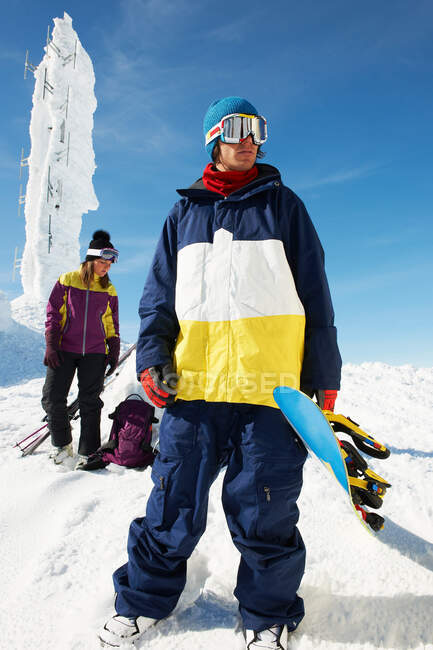 Сноубордист и лыжник на вершине горы с оборудованием, перед ледяной скульптурой — стоковое фото