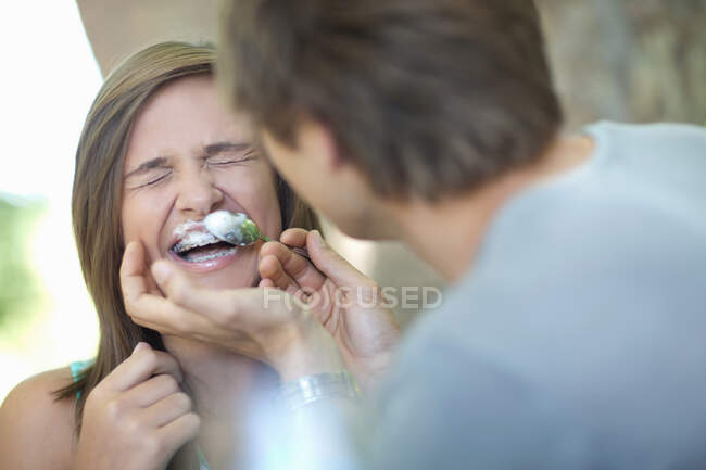 Man wiping coffee foam on girlfriend — Stock Photo