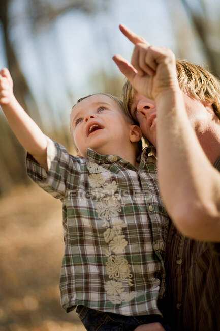 Pai apontando no ar com o jovem filho — Fotografia de Stock