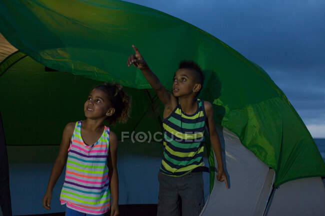Брат и сестра в палатке, мальчик указывает пальцем — стоковое фото