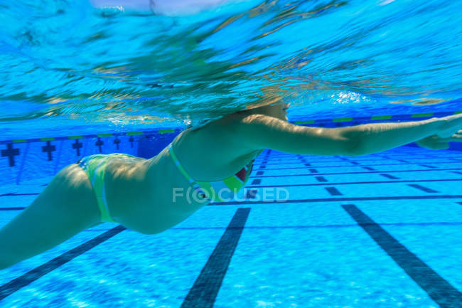 Femme enceinte nageant dans la piscine — Photo de stock
