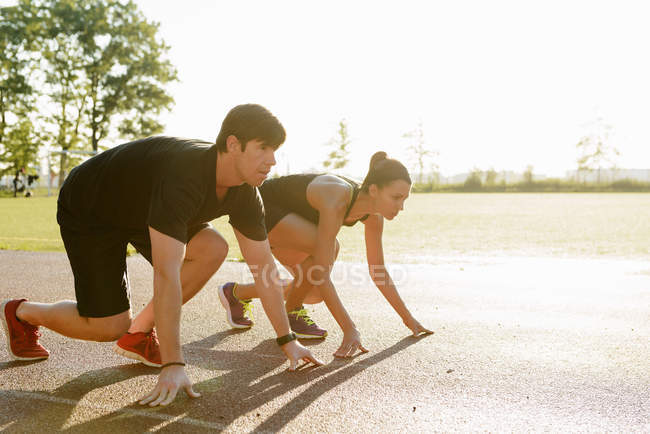 Couple preparing to race in city park early morning — Stock Photo