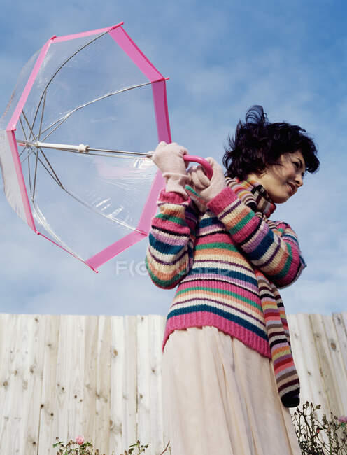 Woman holding a transparent umbrella — Stock Photo