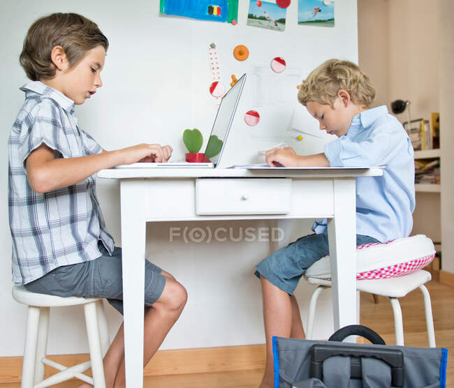 Братья делают домашнее задание на кухне — стоковое фото