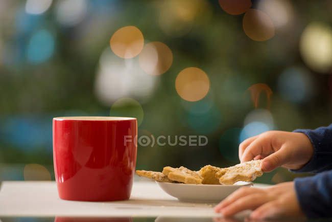 Abgeschnittenes Bild eines Kindes, das Weihnachtsplätzchen nimmt — Stockfoto