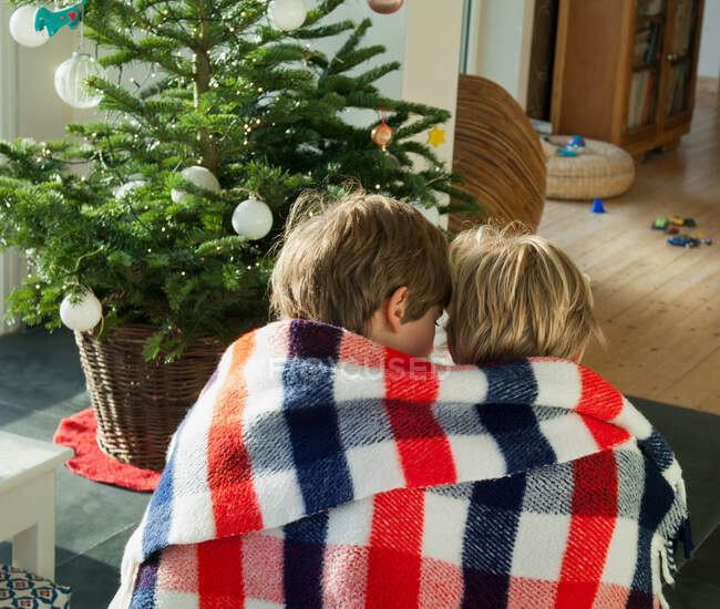 Deux garçons enveloppés dans une couverture ensemble — Photo de stock