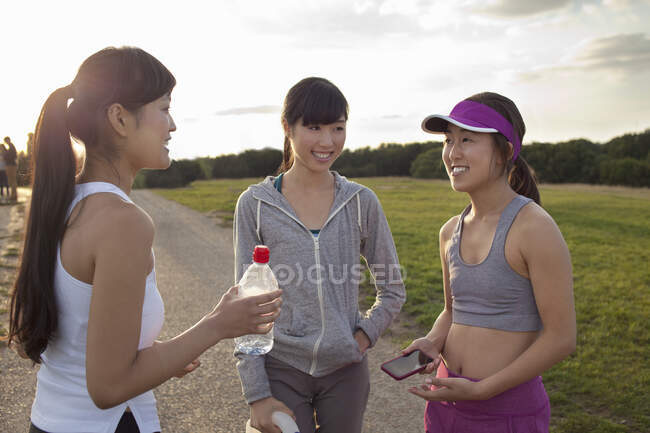Three young female runners chatting after run — Stock Photo