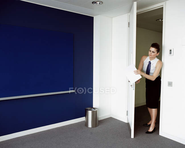 Mujer abriendo la puerta a la oficina - foto de stock