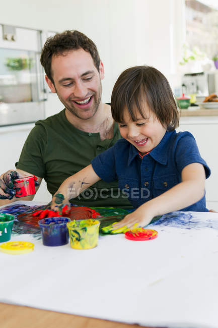 Padre e hijo pintando dedos juntos - foto de stock