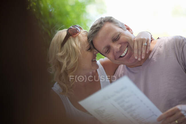 Sorrindo menu de leitura casal ao ar livre — Fotografia de Stock