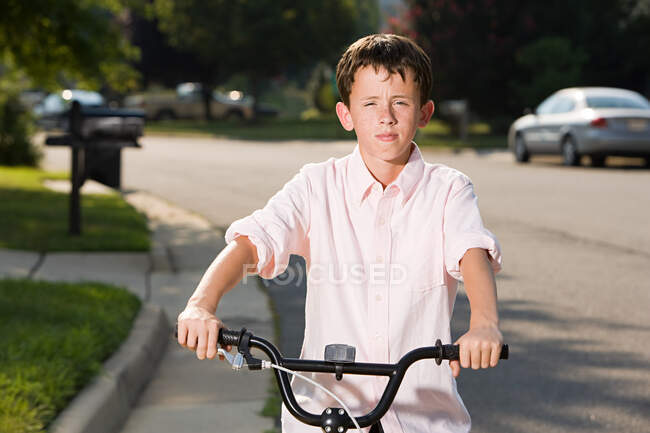 Menino com bicicleta em ambiente suburbano — Fotografia de Stock