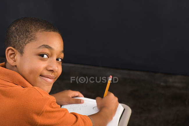 Retrato de un niño escribiendo con lápiz - foto de stock