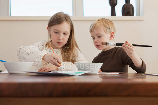 Sister and brother painting pictures — Stock Photo