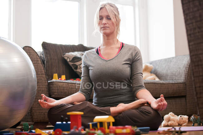 Metà donna adulta in posa yoga a casa — Foto stock
