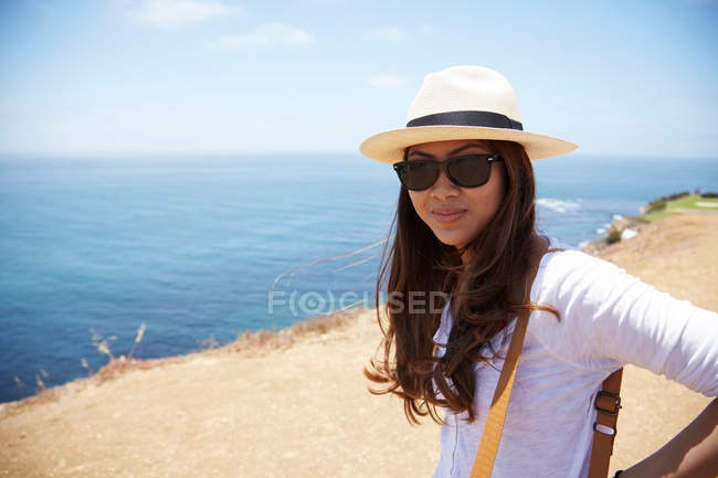 Mujer joven con sombrero de sol en la costa Palos Verdes, California, EE.UU. - foto de stock
