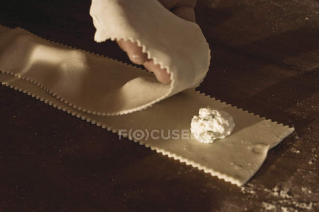 Cook making ravioli in kitchen, close-up partial view — Stock Photo
