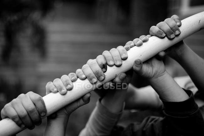 Children holding on to railing, black and white — Stock Photo