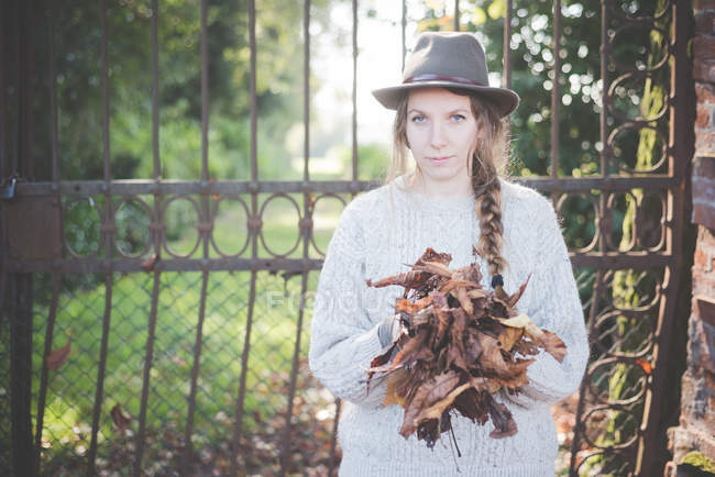 Giovane donna che raccoglie foglie di autunno — Foto stock