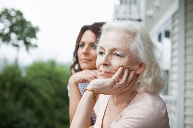 Femme âgée et fille se détendre sur le porche — Photo de stock