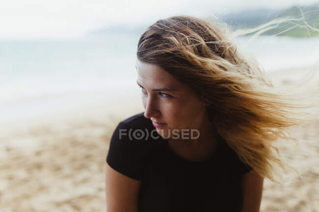 Retrato de la mujer en la playa mirando hacia otro lado, Oahu, Hawaii, EE.UU. - foto de stock