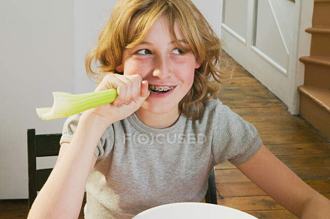 Girl biting a celery stick — Stock Photo