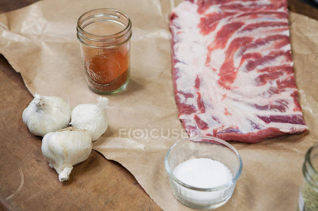 Pork ribs and with oil and garlic bulbs — Stock Photo