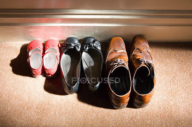 Scarpe di famiglia in fila su pavimento — Foto stock