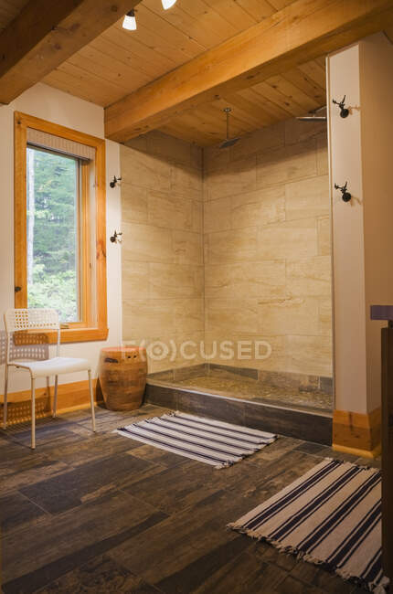 Cabine de douche en céramique dans la salle de bain principale au rez-de-chaussée à l'intérieur d'une cabane en bois rond de style chalet, Québec, Canada. Cette image est une propriété libérée. CUPR0291 — Photo de stock