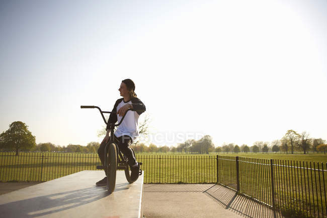 Giovanotto in bici bmx allo skatepark — Foto stock