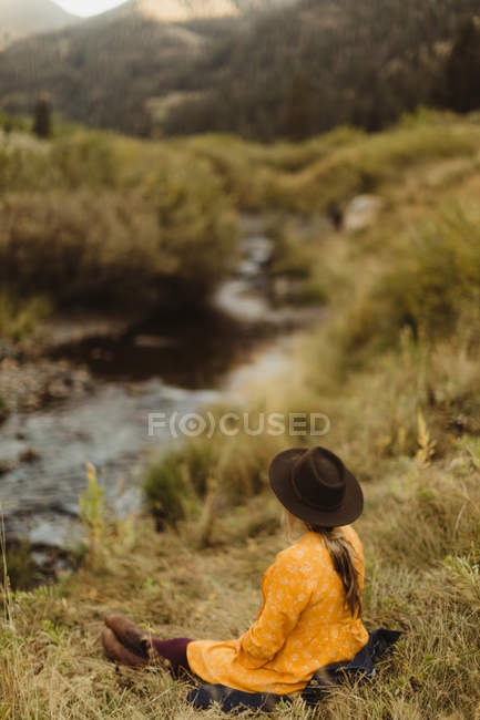 Woman sitting by stream, rear view, Mineral King, Sequoia National Park, California, USA — Stock Photo
