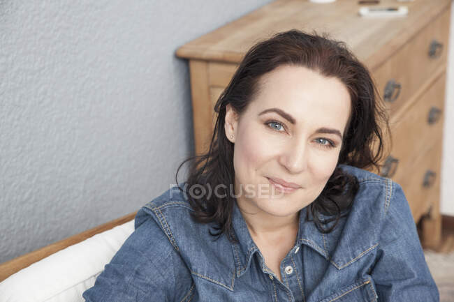 Голова и плечи портрет взрослой женщины в джинсовой рубашке — стоковое фото