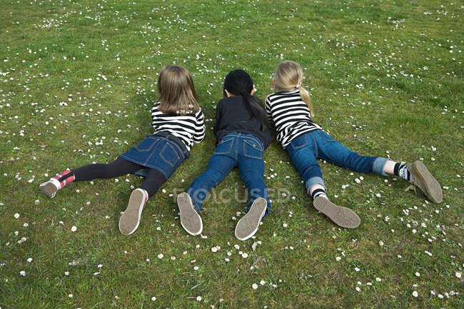 Три девушки лежат на траве — стоковое фото
