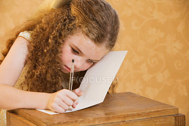 Mädchen schreibt eine Grußkarte — Stockfoto
